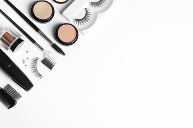 Photo of Composition with false eyelashes and other makeup products on white background, top view