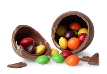 Photo of Tasty broken chocolate egg with colorful candies isolated on white