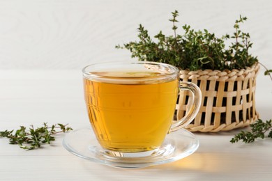 Photo of Aromatic herbal tea with thyme on white wooden table