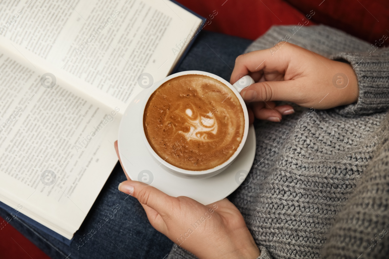 Photo of Woman with cup of coffee reading book at home, above view