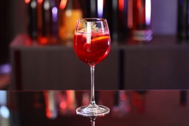 Photo of Glass of delicious refreshing sangria on counter in bar