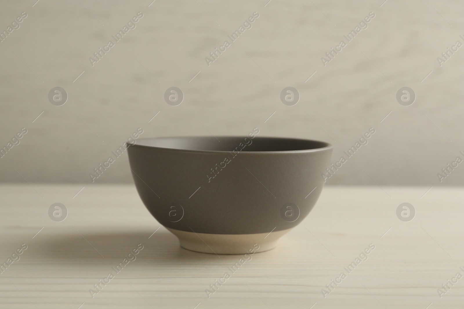 Photo of Stylish empty ceramic bowl on white wooden table. Cooking utensil