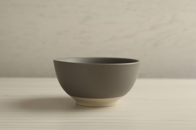 Stylish empty ceramic bowl on white wooden table. Cooking utensil