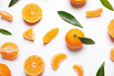 Photo of Composition with fresh ripe tangerines and leaves on white background, flat lay. Citrus fruit