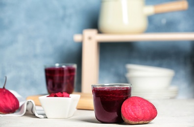 Photo of Glass of beet smoothie on table against blurred background