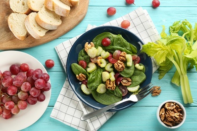 Delicious fresh celery salad served on light blue wooden table, flat lay