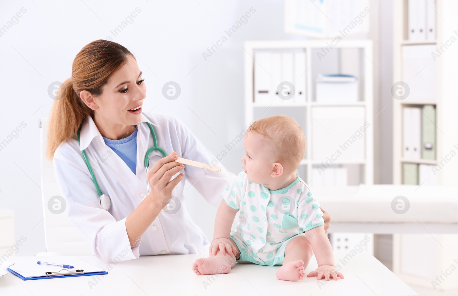 Photo of Children's doctor examining baby's throat in hospital