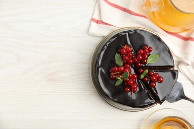 Tasty homemade chocolate cake served with berries, mint and tea on white wooden table, flat lay. Space for text