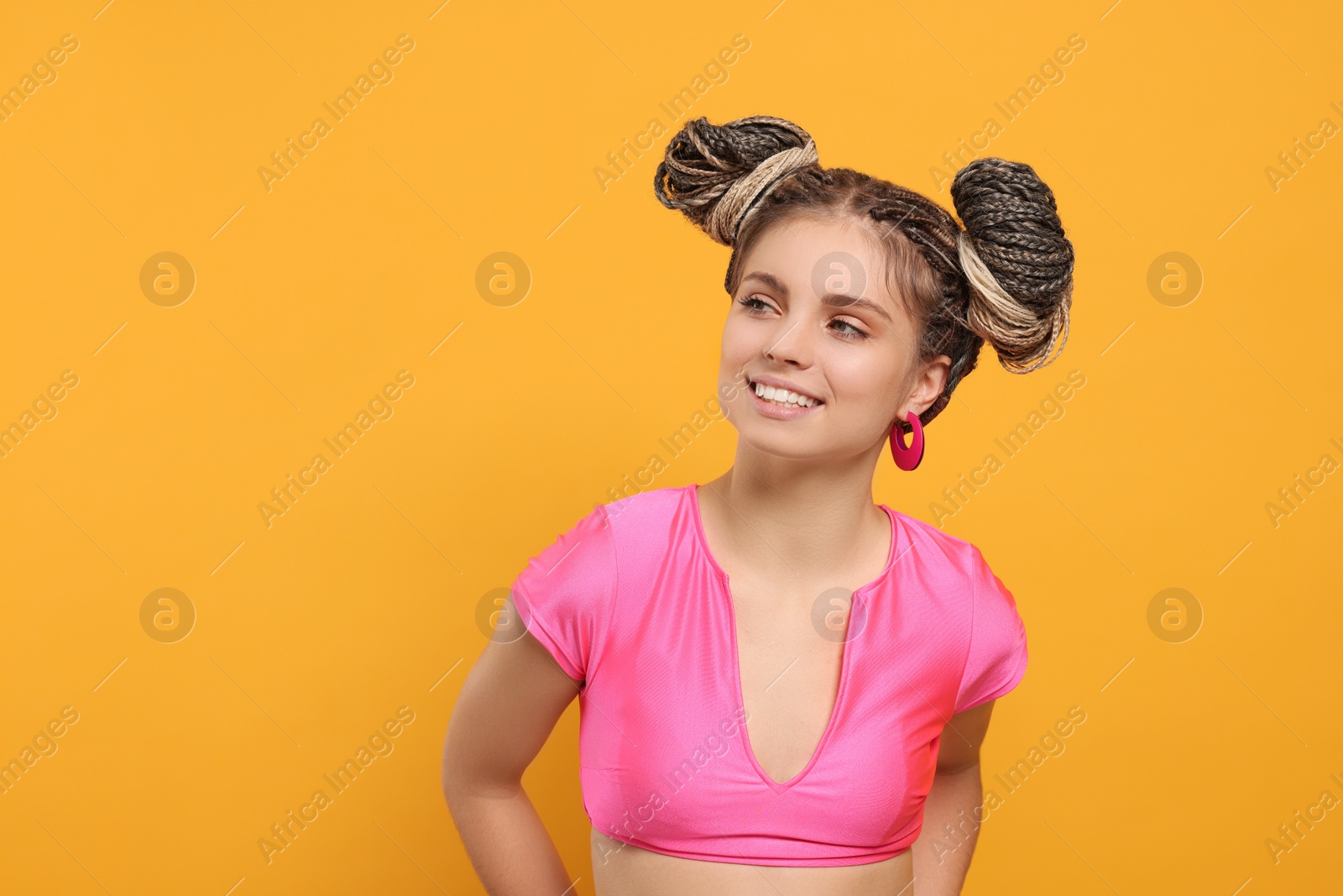 Photo of Beautiful woman with braided double buns on yellow background, space for text