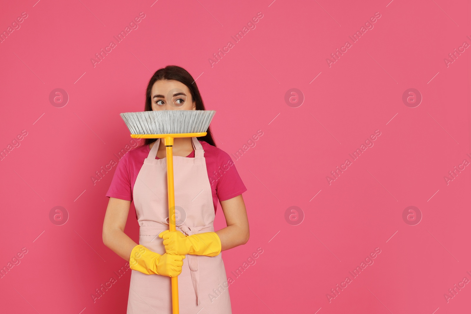 Photo of Beautiful young woman with broom on pink background. Space for text