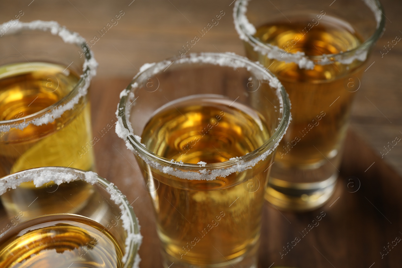 Photo of Mexican Tequila shots with salt on table, closeup