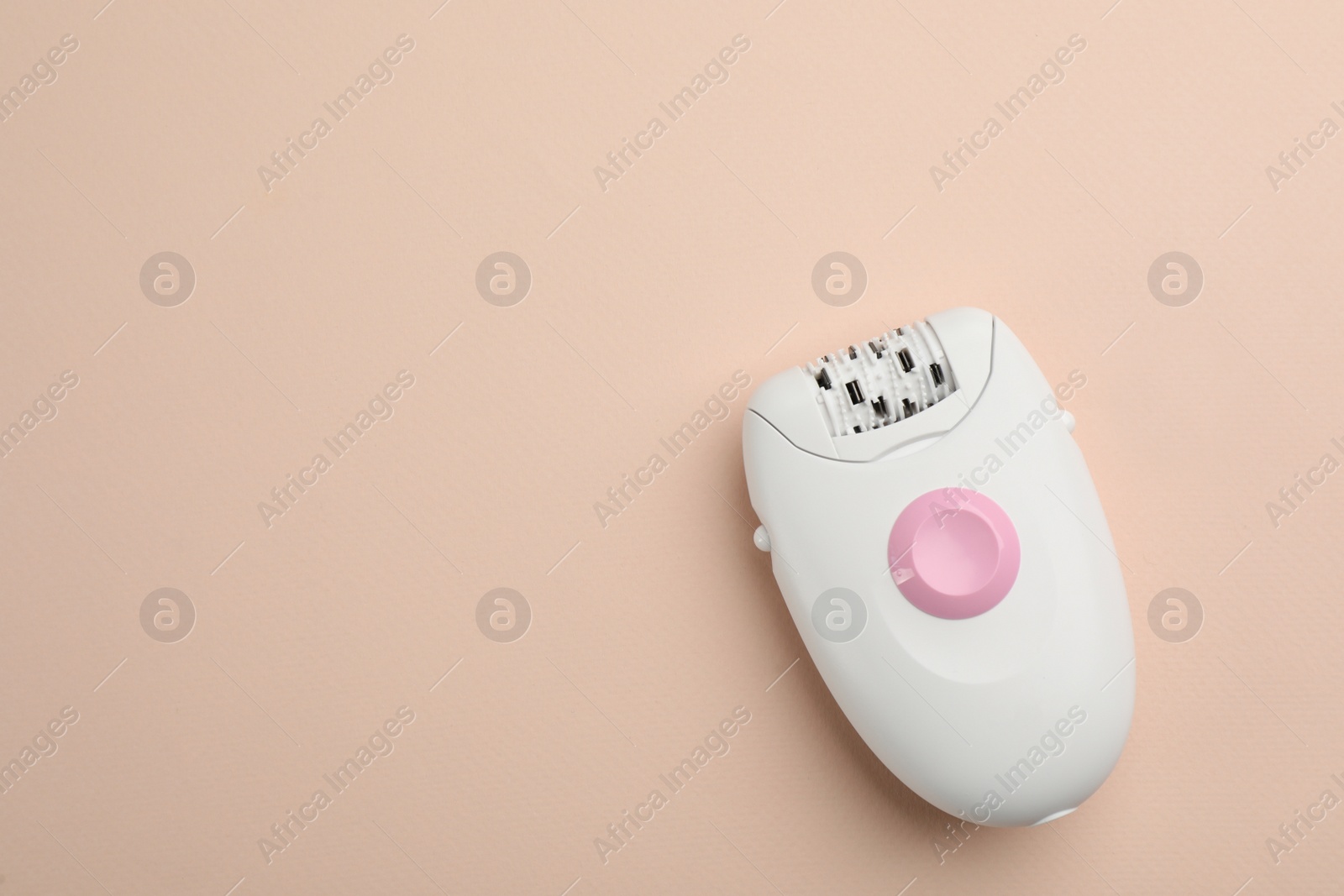 Photo of Modern epilator on beige background, top view. Space for text