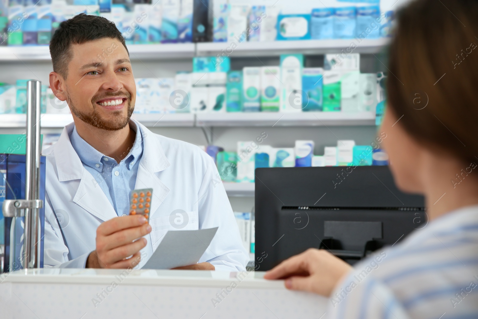 Photo of Professional pharmacist working with customer in drugstore