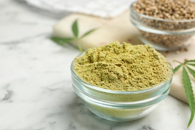 Bowl of hemp protein powder on marble table. Space for text