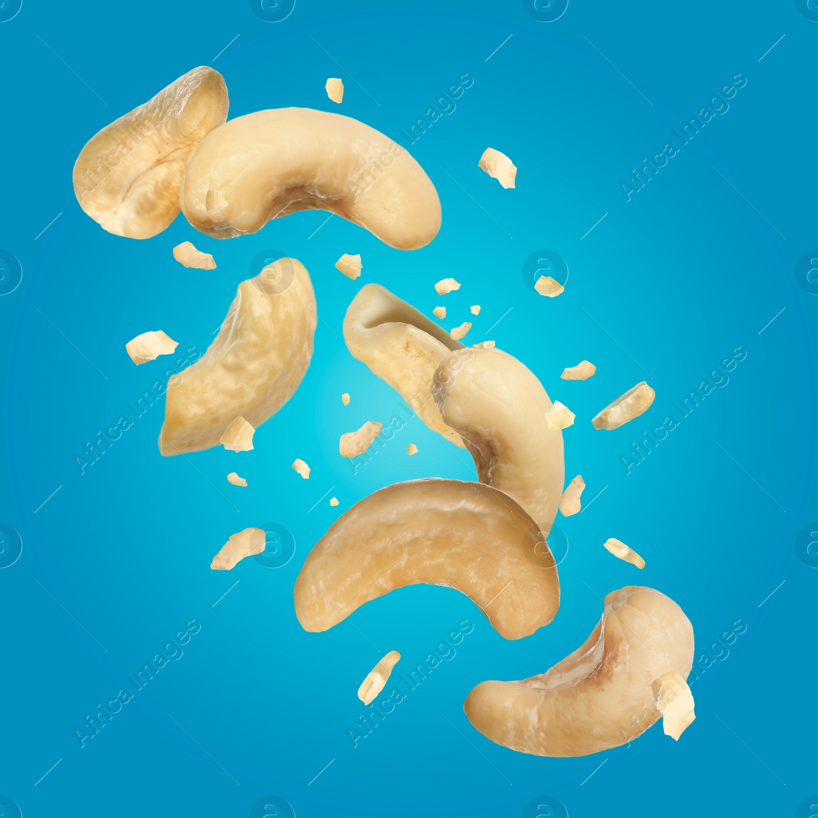 Image of Tasty cashew nuts flying on turquoise background