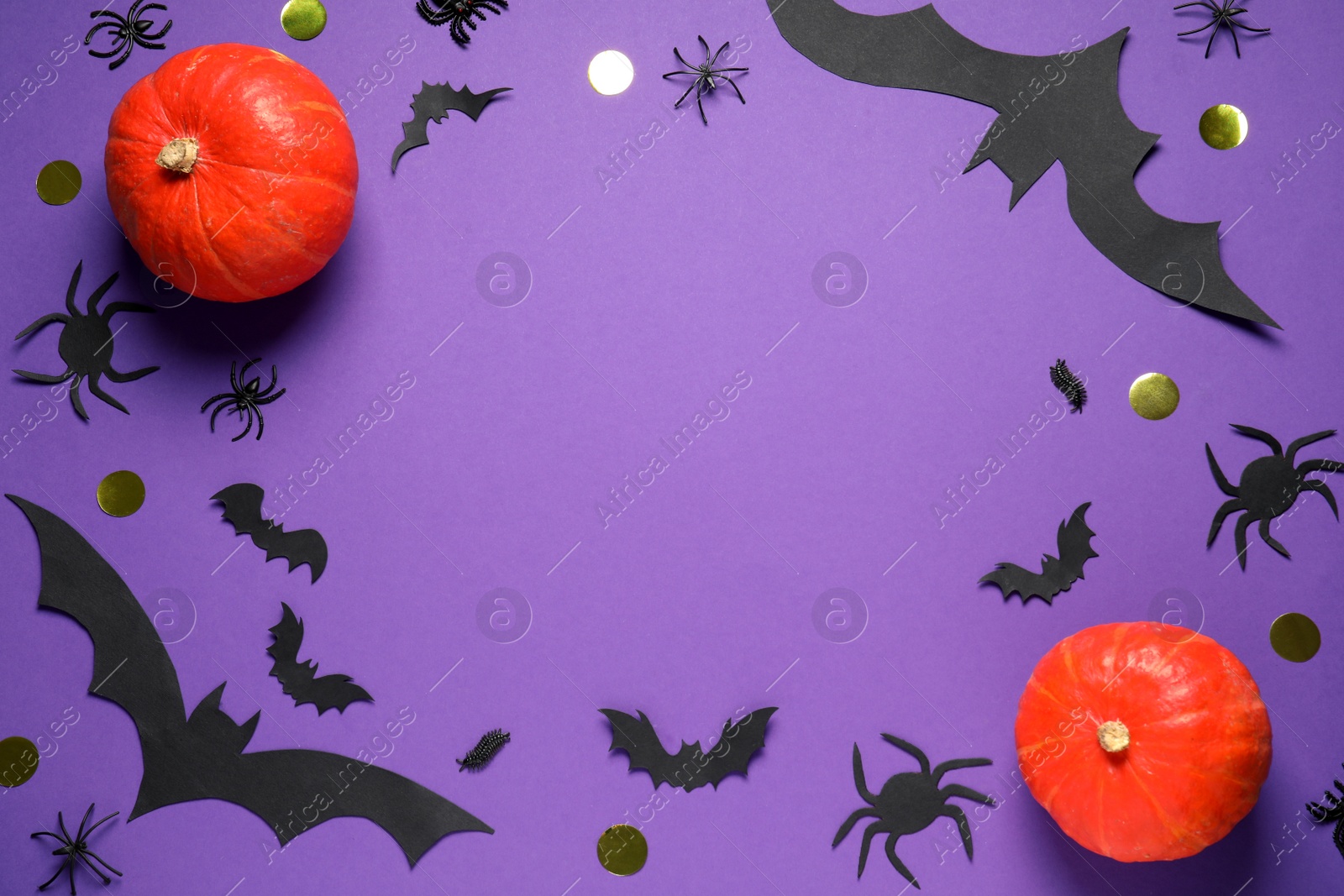 Photo of Frame made with Halloween decor on purple background, flat lay. Space for text