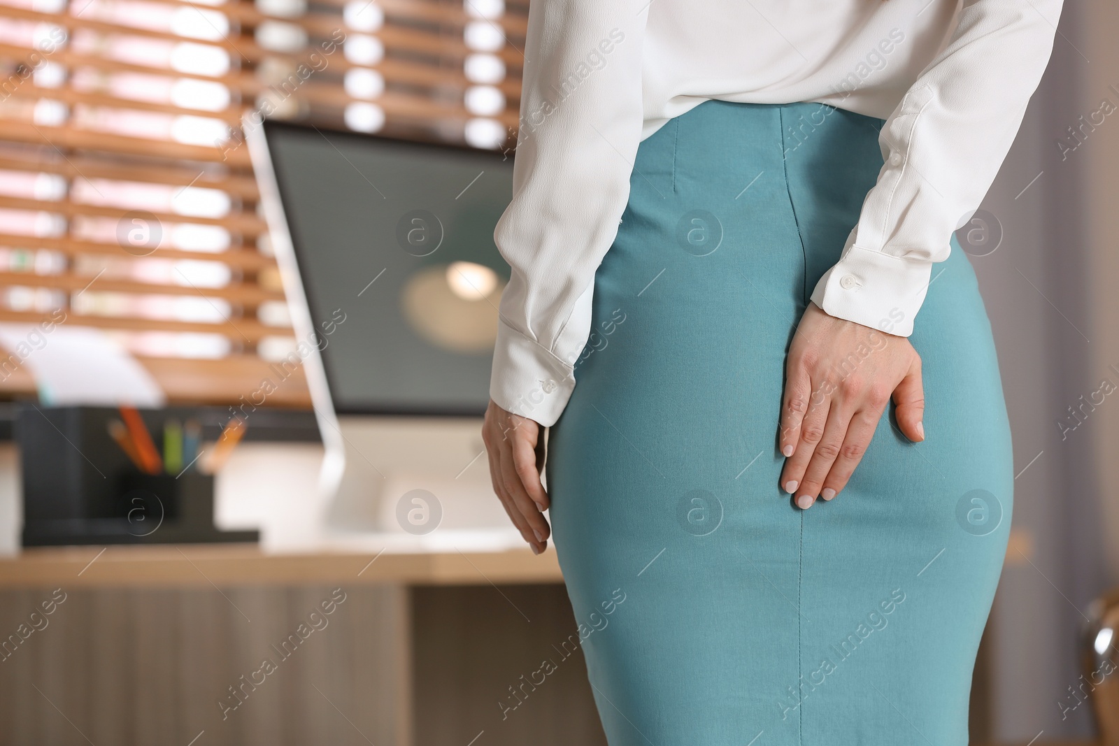 Photo of Young woman suffering from hemorrhoid in office, closeup