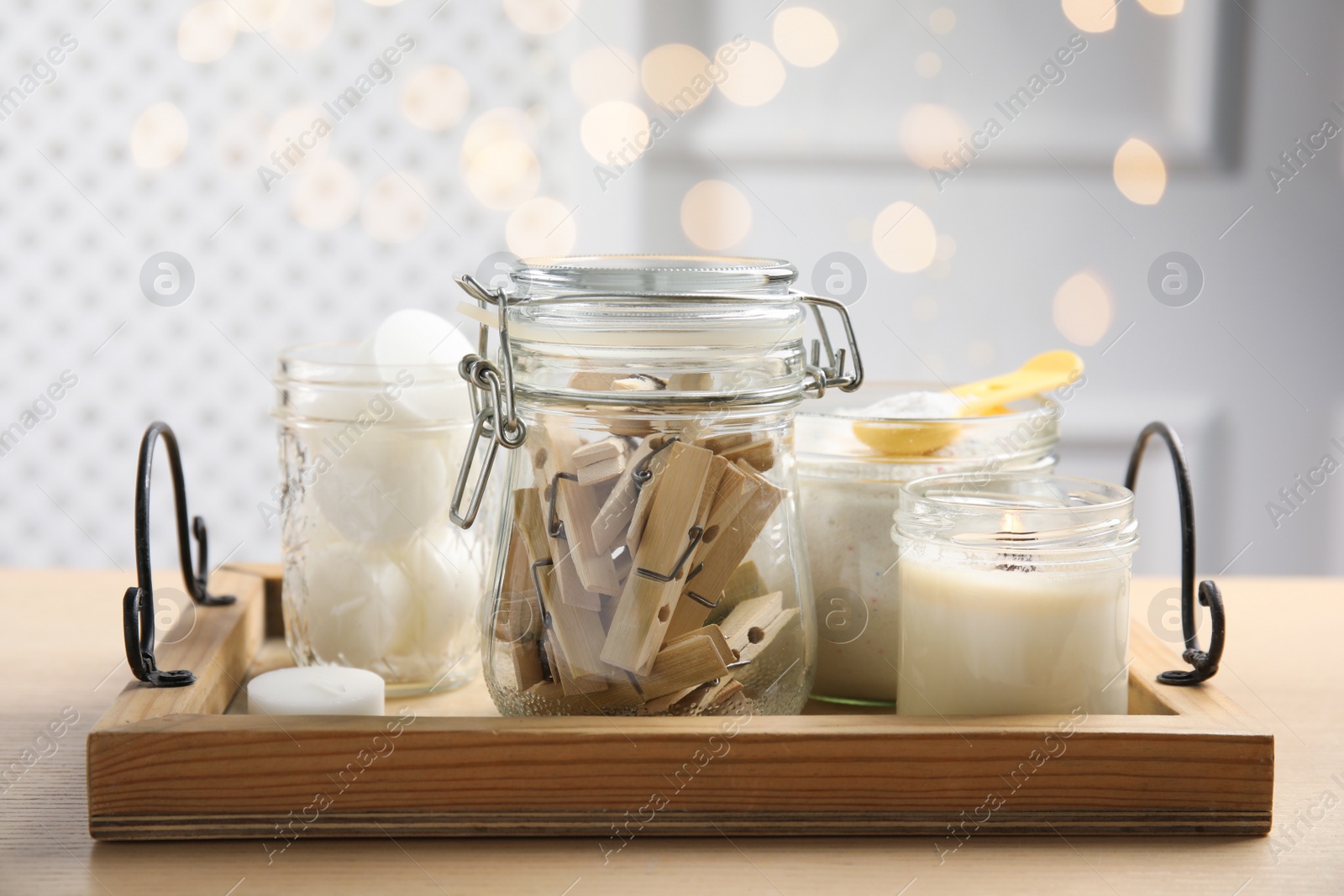 Photo of Tray with wooden clothespins, laundry powder and candles on table indoors