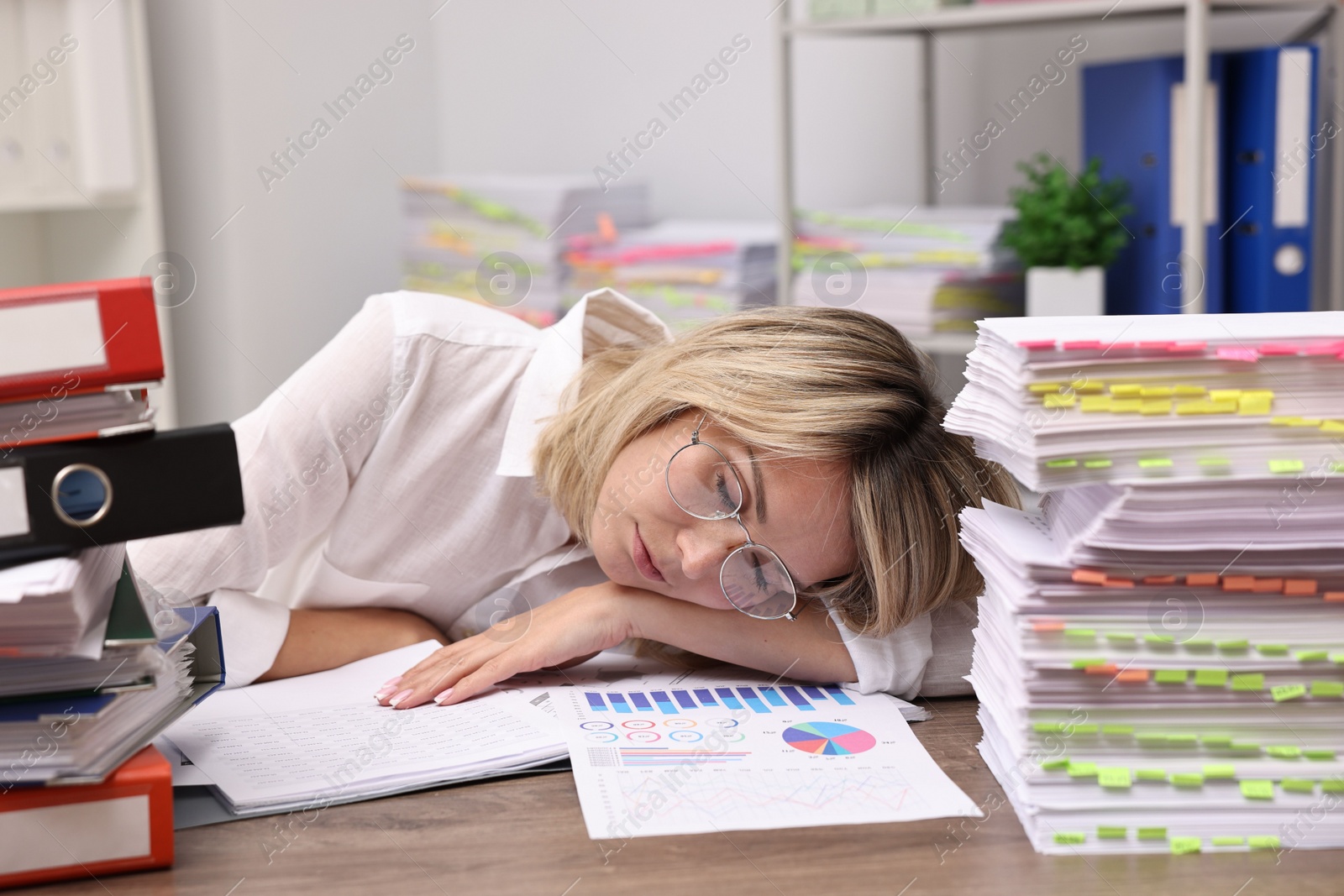 Photo of Office worker sleeping at workplace. Overwhelmed by work