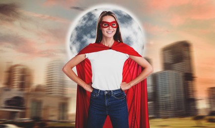 Woman wearing superhero costume and beautiful cityscape on background