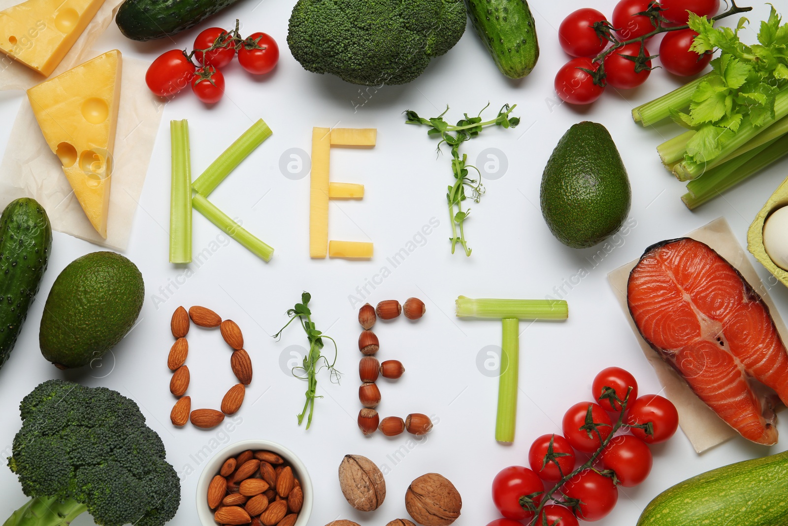 Photo of Phrase Keto Diet made with products surrounded by different food on white background, flat lay