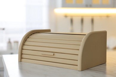 Wooden bread box on white table in kitchen, closeup