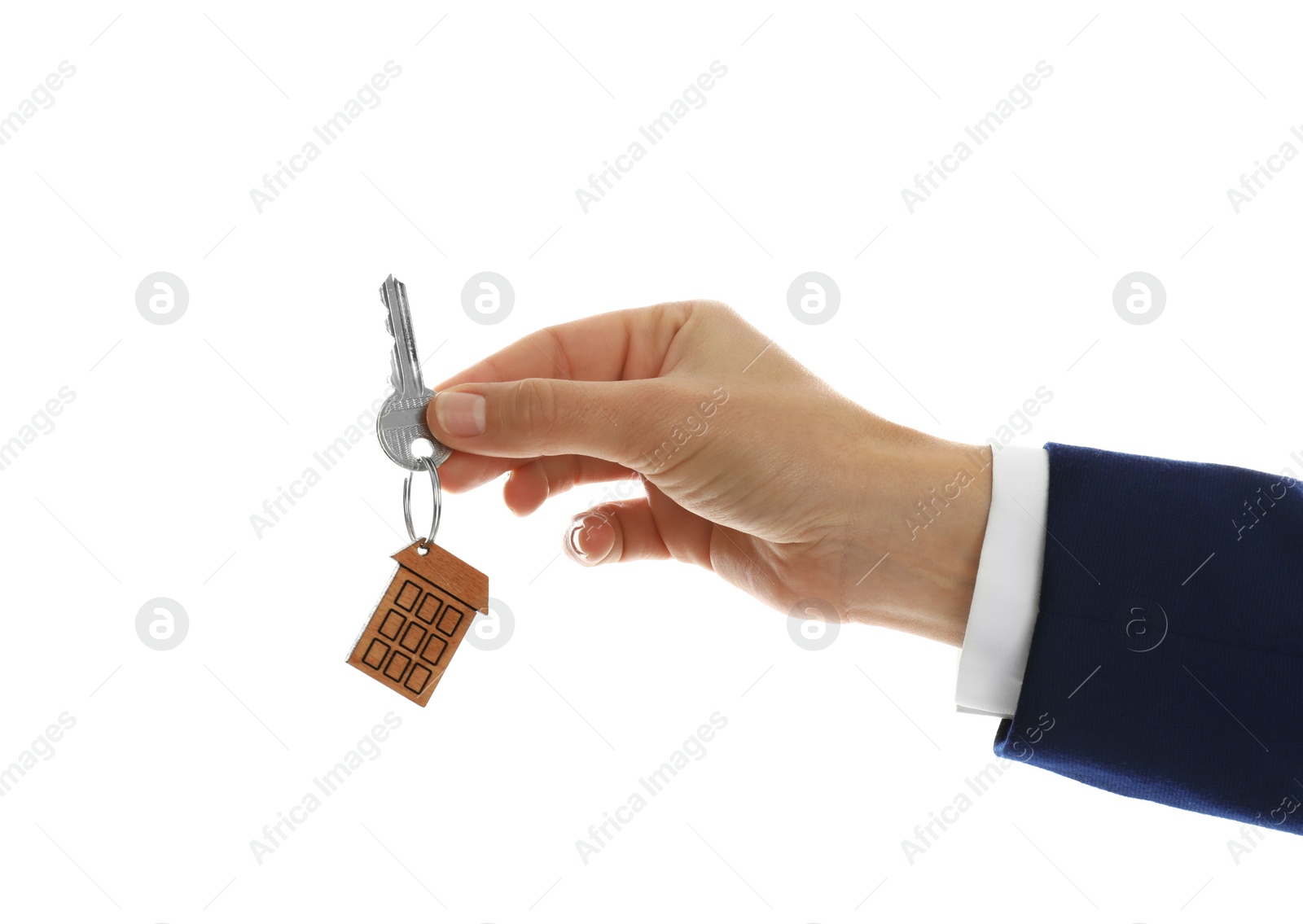 Photo of Real estate agent holding house key with trinket on white background, closeup