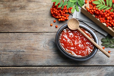 Delicious rowan jam and berries on wooden table, flat lay. Space for text