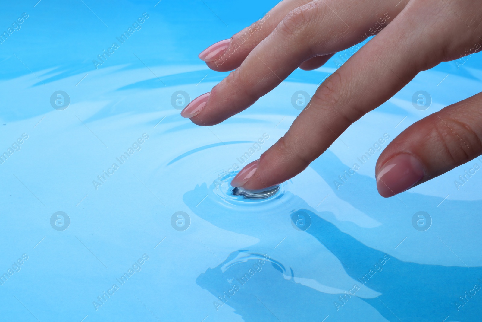 Photo of Woman touching clear water, closeup. Making ripples