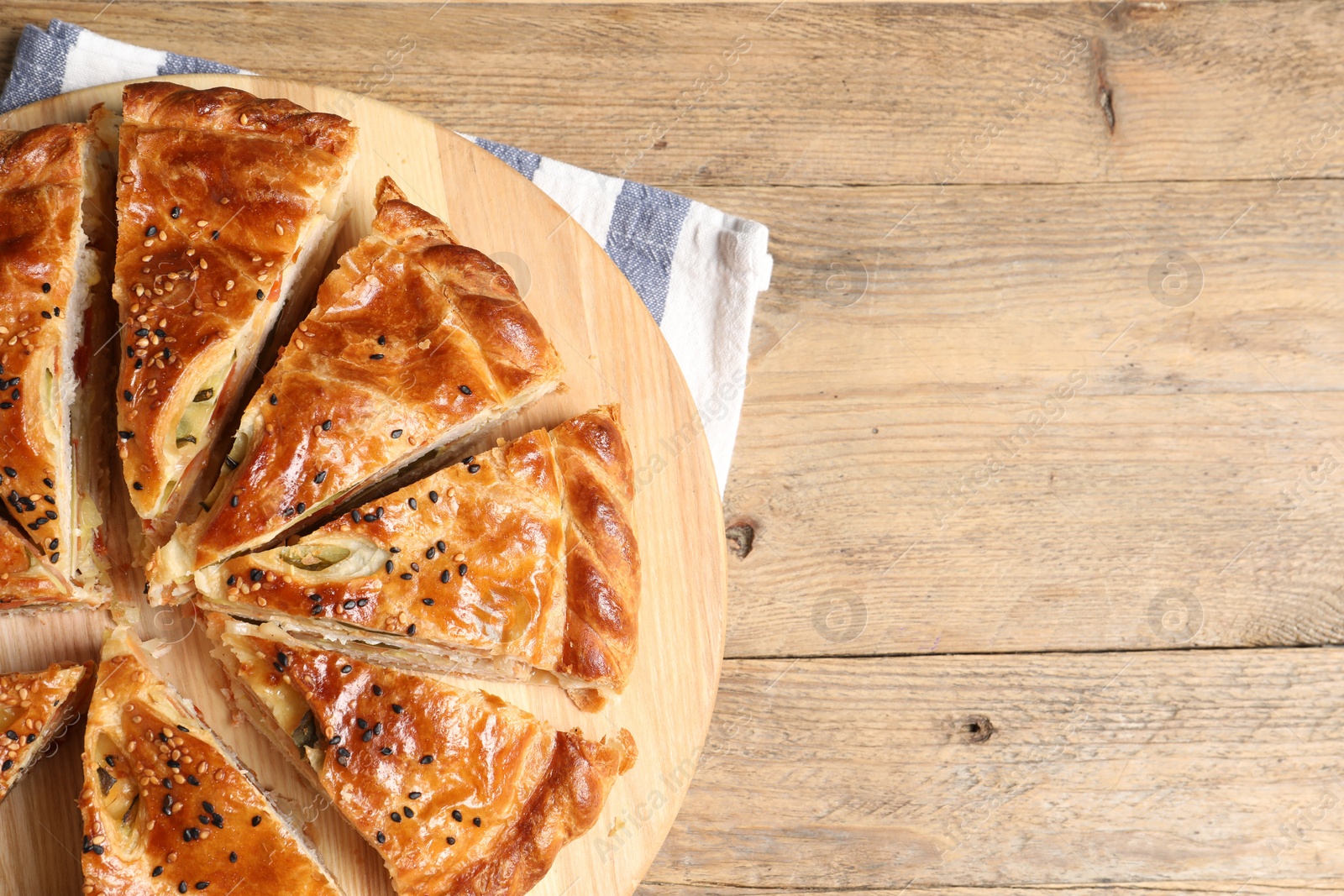 Photo of Cut delicious homemade pie on wooden table, top view. Space for text