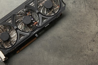 One computer graphics card on grey textured table, top view. Space for text