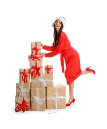 Woman in red dress and Santa hat with Christmas gifts on white background