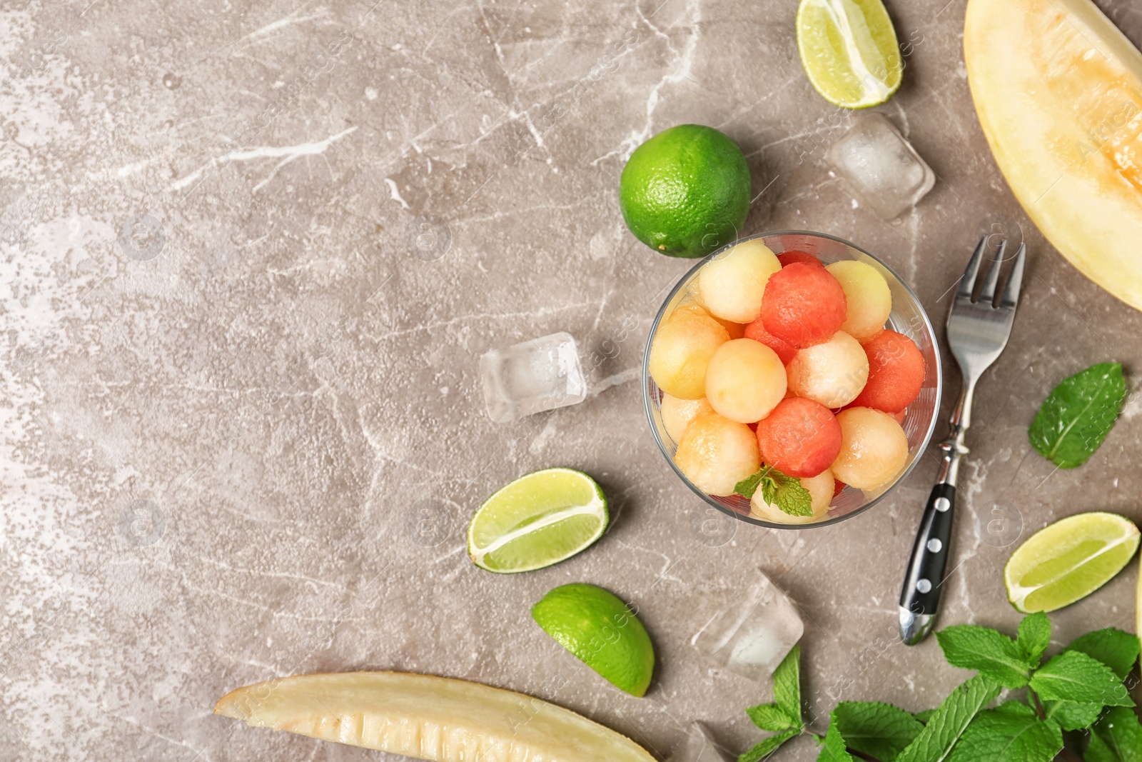 Photo of Flat lay composition with melon and watermelon balls on brown marble table. Space for text