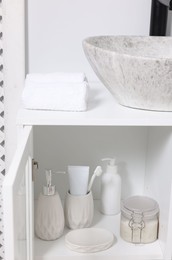 Photo of Different personal care products and bath accessories in bathroom vanity