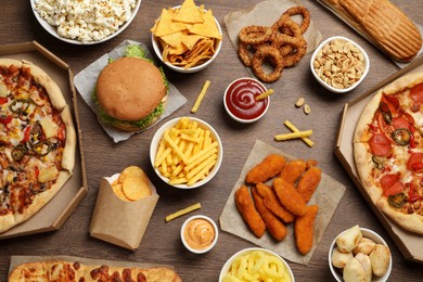Photo of French fries, chips and other fast food on wooden table, flat lay