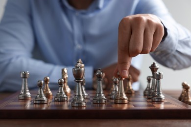 Photo of Man playing chess during tournament at table, closeup