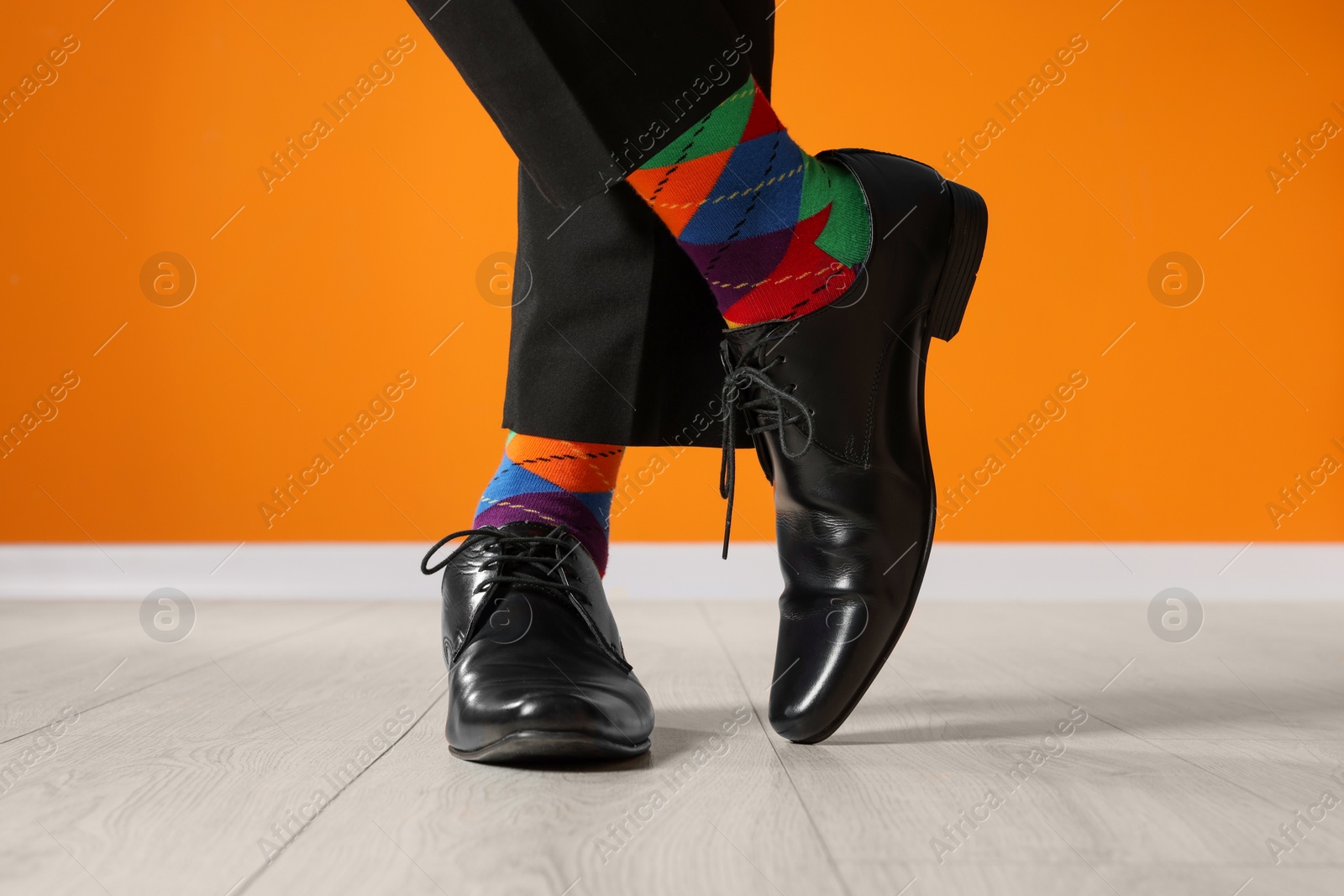 Photo of Man wearing stylish shoes and colorful socks indoors, closeup