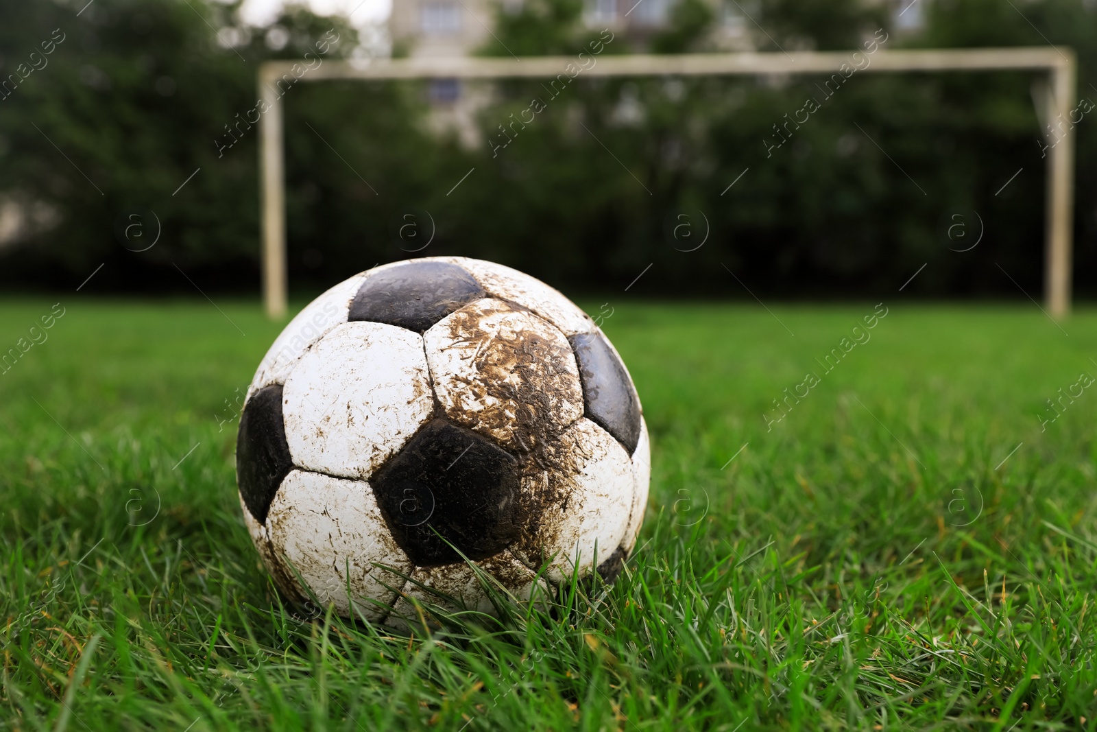 Photo of Dirty soccer ball on green grass outdoors, space for text