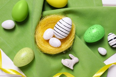 Photo of Flat lay composition with festively decorated Easter eggs on white wooden table