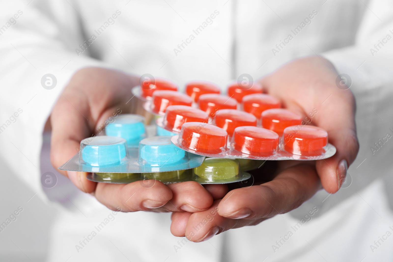 Photo of Woman holding blisters with cough drops, closeup