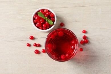 Tasty refreshing cranberry juice, mint and fresh berries on light wooden table, flat lay