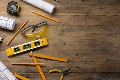 Photo of Flat lay composition with building level and other construction tools on wooden table, space for text