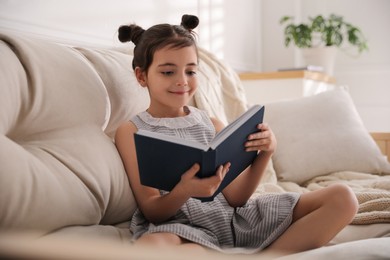 Little girl reading fairy tale in living room