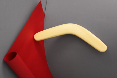 Creative composition with yellow wooden boomerang on color background