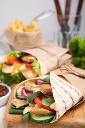 Delicious shawarma with chicken and fresh vegetables on table, closeup
