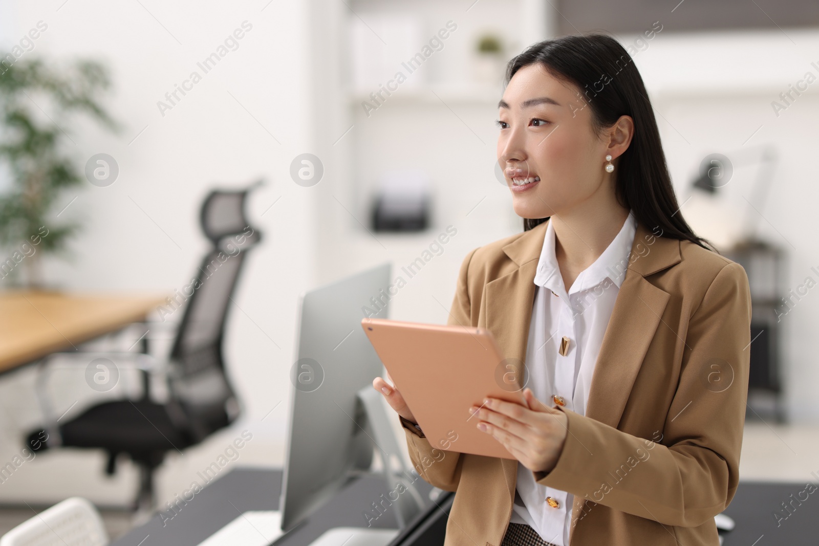 Photo of Portrait of smiling businesswoman with tablet in office. Space for text