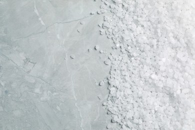 Photo of Natural sea salt on light grey marble table, top view. Space for text