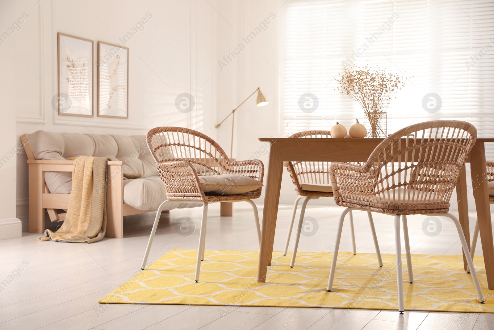 Photo of Dining room interior with wooden table and wicker chairs