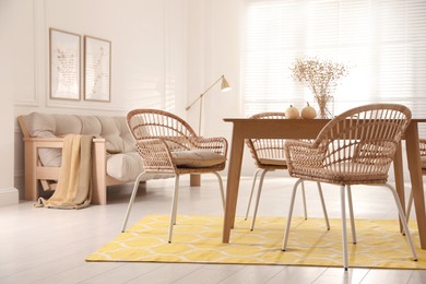 Dining room interior with wooden table and wicker chairs