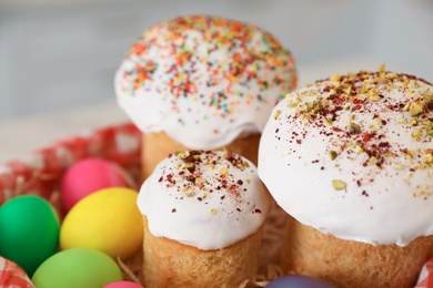 Traditional Easter cakes and dyed eggs on blurred background, closeup